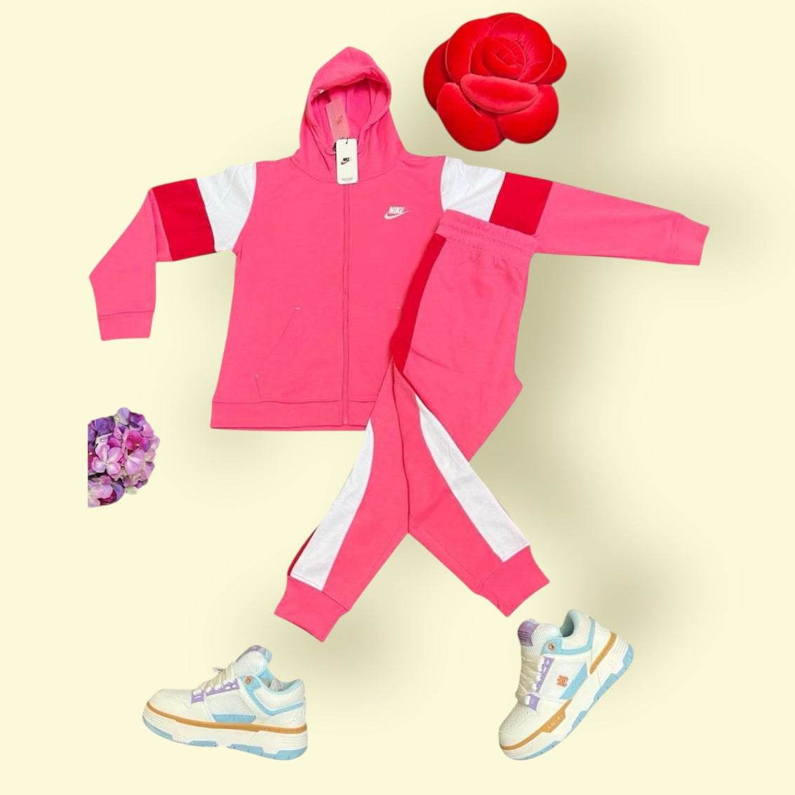 Pink Nike tracksuit hoodie and pants with white and red accents, paired with sneakers and decorative flowers, Nike Tracksuit & Amiri bundle for women