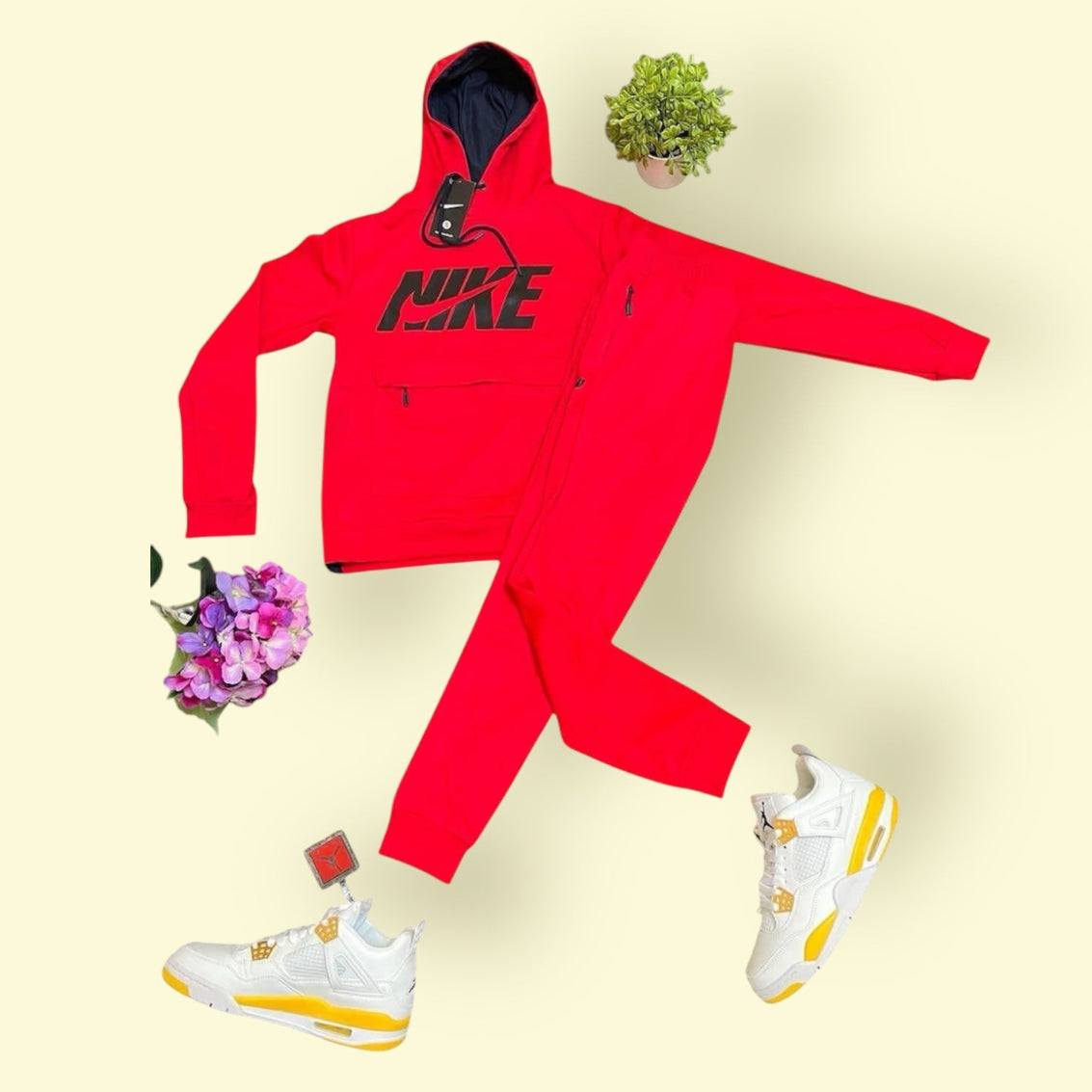 Red Nike tracksuit with black logo paired with white and yellow Air Jordan 4 Retro sneakers on a light background