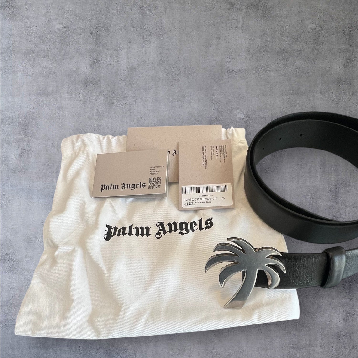 Palm Angels black leather belt with silver palm tree buckle on branded white pouch and tags